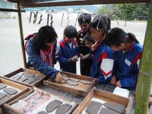 Children in Japan look inside a kiosk where clay cut-outs are laid out