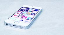 A white iPhone laying flat on a table. 