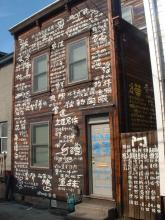 Chinese calligraphy covers a wood-slat house