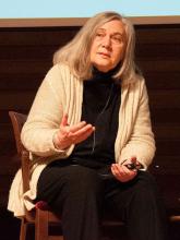 Marilynne Robinson sitting on a chair and talking to an audience.