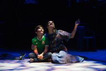 Two actors sit on the stage and look at the sky