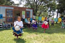 young girls dancing in the parks in front of a mobile art studio