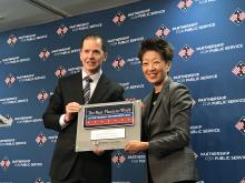 A man and a woman pose holding a plaque which says "The Best Places to Work in the Federal Government 2017"