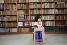 Young boy sitting at table with a book