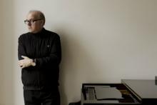Man standing next to a piano