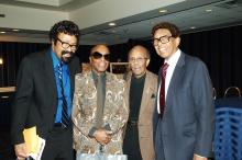 Four men stand together in a hotel ballroom