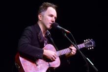 Musician Walter Martin performing with guitar in hand.