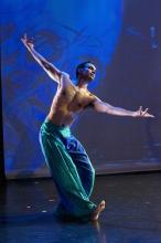 a mal Indian dancer in billowing green pants strikes a pose