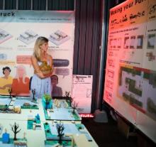 A woman looks at a series of large posters as part of a design exhibit