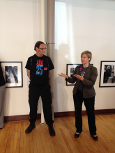 Photographer Tom Olin standing in front of his photographs