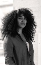 a black and white photo of a fair-skinned young woman with very long dark curly hair