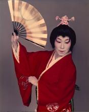 A female Japanese classical dancer in white face paint, a dark updo wig, holding a fan