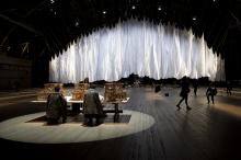 Big billowy sheets hanging from ceiling in front of table with crates on it