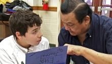 a young boy and an older man work on an art project together