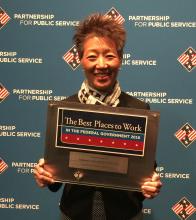 chairman chu holds an award plaque