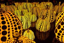 Rows of yellow glowing glass pumpkins covered with black polka dots