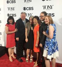 6 people in group in front of banner with Tony Awards and CBS logos
