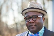 an African American man in glasses and a small straw fedora