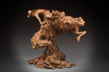 photo of a bronze sculpture of a cowboy riding a bucking horse