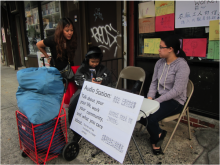 a woman sits outside a laundromat with a sign