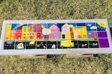 a colorful concrete bench decorated with children's drawings