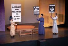 Three actresses portray suffragettes in a scene from a play
