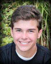 headshot of a smiling white young man with dark hair