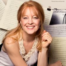 Composer Maria Schnedier against a background of music notation paper