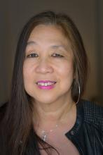 an older Asian-American woman with long dark hair and bright pink lipstick