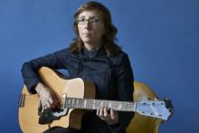 Woman in glasses holding a guitar