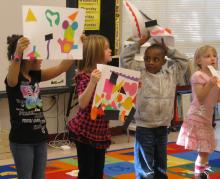 Children in school showing art work