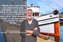 a bearded older white man on a dock in front of a boat
