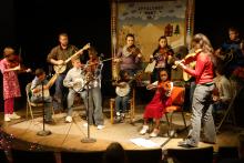 Small stage with young people playing musical instruments