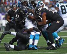 Football players tackling one another. 