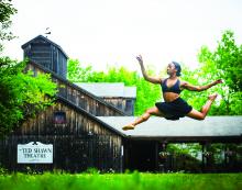 African-American dancer leaping in air before performing center.