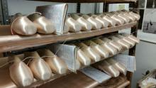 Rows of pink pointe shoes on a shelving unit