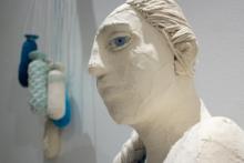 A white bust of a woman with one giant blue eye