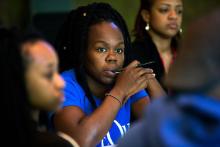 three African-American woman theater artists watching a performance that is out of the frame