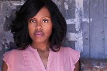 a young black woman with straightened hair and pink lipstick