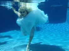 Drag queen in wedding dress underwater