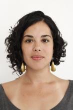 Headshot of a woman with dark hair and gold earrings