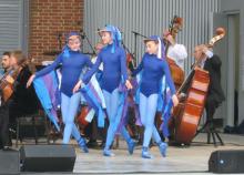 young dancers and orchestra musicians on stage