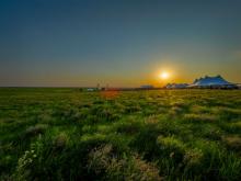 White tents at sunsets in middle of Kansas grassland prairie