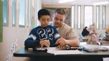 a young boy and his father dressed in a prison jumpsuit color together