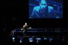 Woman on stage with screen behind her
