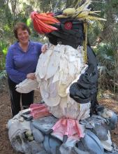the artist Angela Pozzi poses with a penguin made of plastic waste pulled from the ocean