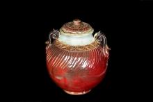 an oxblood red large covered ceramic vessel