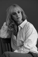 Blonde woman in white shirt sitting down
