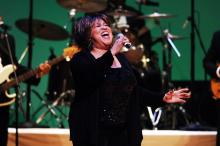 A woman sings into a microphone.