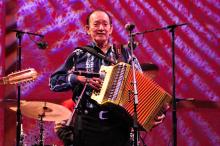 Man on stage playing accordion. 